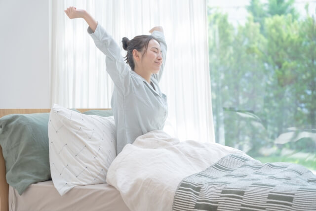 ベッドで起きる女性