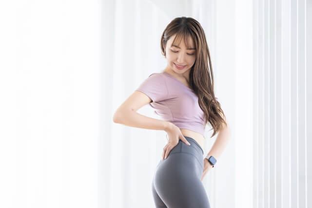 ウエストを捻って体のチェックをする女性