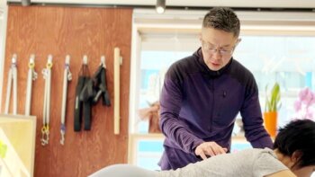 カメシチのトレーナーがマシンピラティスで背骨を動かしている